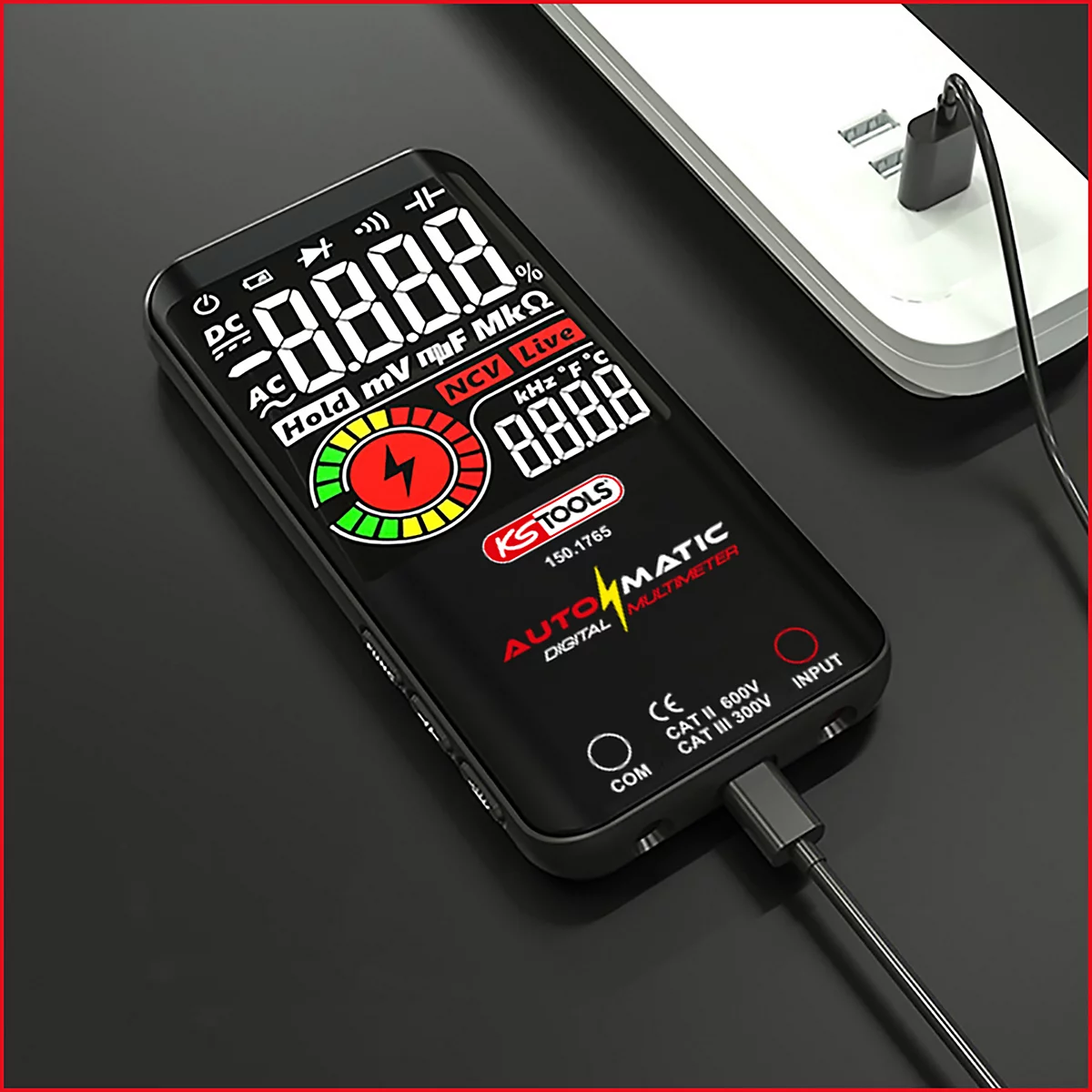 Digitales Multimeter, schwarz, wird über ein Kabel aufgeladen. Display mit Messwerten und rotem Blitzsymbol. Aufschrift: KS TOOLS.